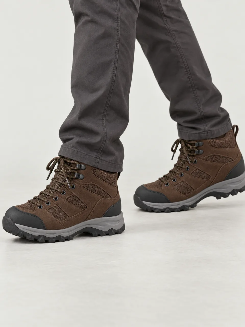 Man in his 40s, white, medium build, mid-stride on a wet moorland track, framed from the knee down wearing the Hale Men's Dene II Waterproof Walking Boot in Peat