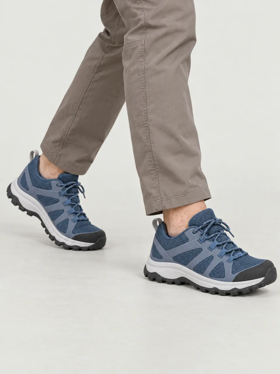 Woman in her 40s, white Irish, freckled, medium build, moving quickly along a rocky ridge path, framed from the knee down wearing the Swift Women's Dart 290 Waterproof Hiking Shoe in Tarn