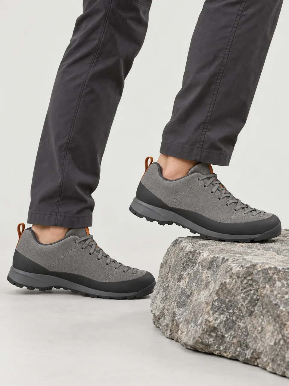 Man in his 30s, East Asian, lean build, stepping up a grey rock slab, framed from the knee down wearing the Scree Line Men's Gabbro 5 Approach Shoe in Ash Grey