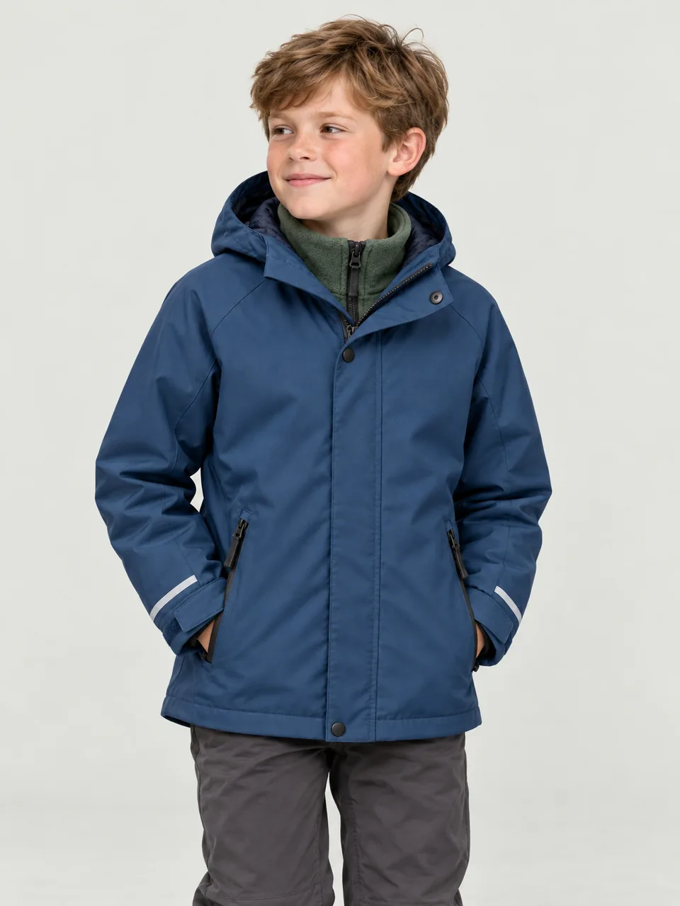 Boy about 9, white, walking along a muddy farm track in low autumn light, hands in pockets wearing the Hale Kids' Garth 3-in-1 Jacket in Tarn