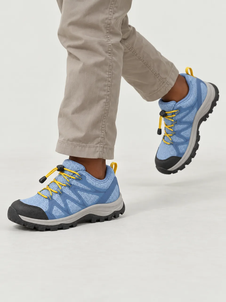 Girl about 9, Black British, running along a gravel path, cropped to feet and lower legs wearing the Swift Kids' Turnstone 250 Trail Shoes in Sky