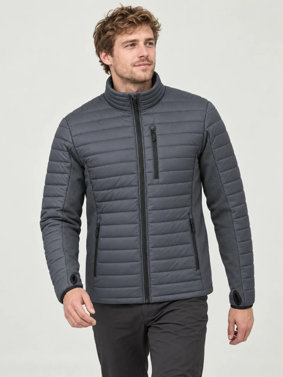White man in his 20s, tall and lean, walking up a moorland track on a frosty morning wearing the Hale Men's Keld Hybrid Insulated Jacket in Slate