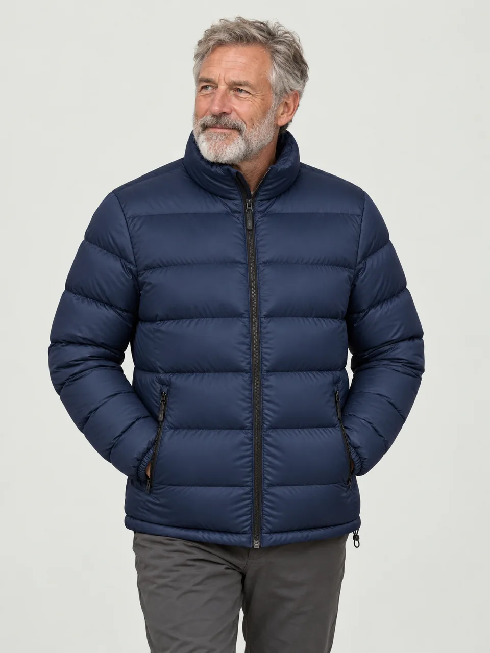 White man in his 60s, grey beard, walking a frosty lane with his hands in his pockets wearing the Northwold Men's Hoar 700 Down Jacket in Navy