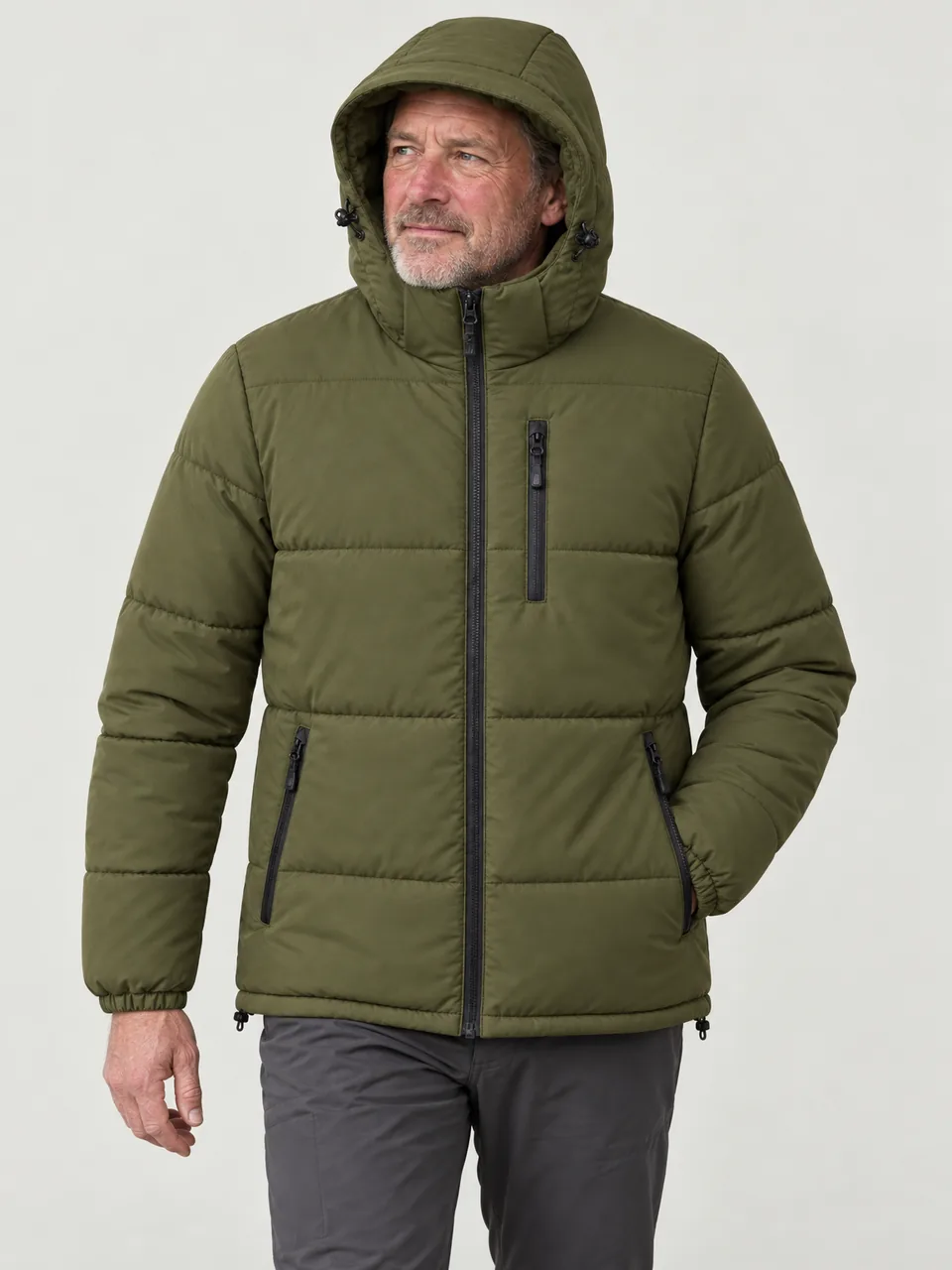 White man in his 50s, wind-reddened face, walking a bog road in drizzle, hood up wearing the Northwold Men's Thaw 100 Synthetic Jacket in Olive